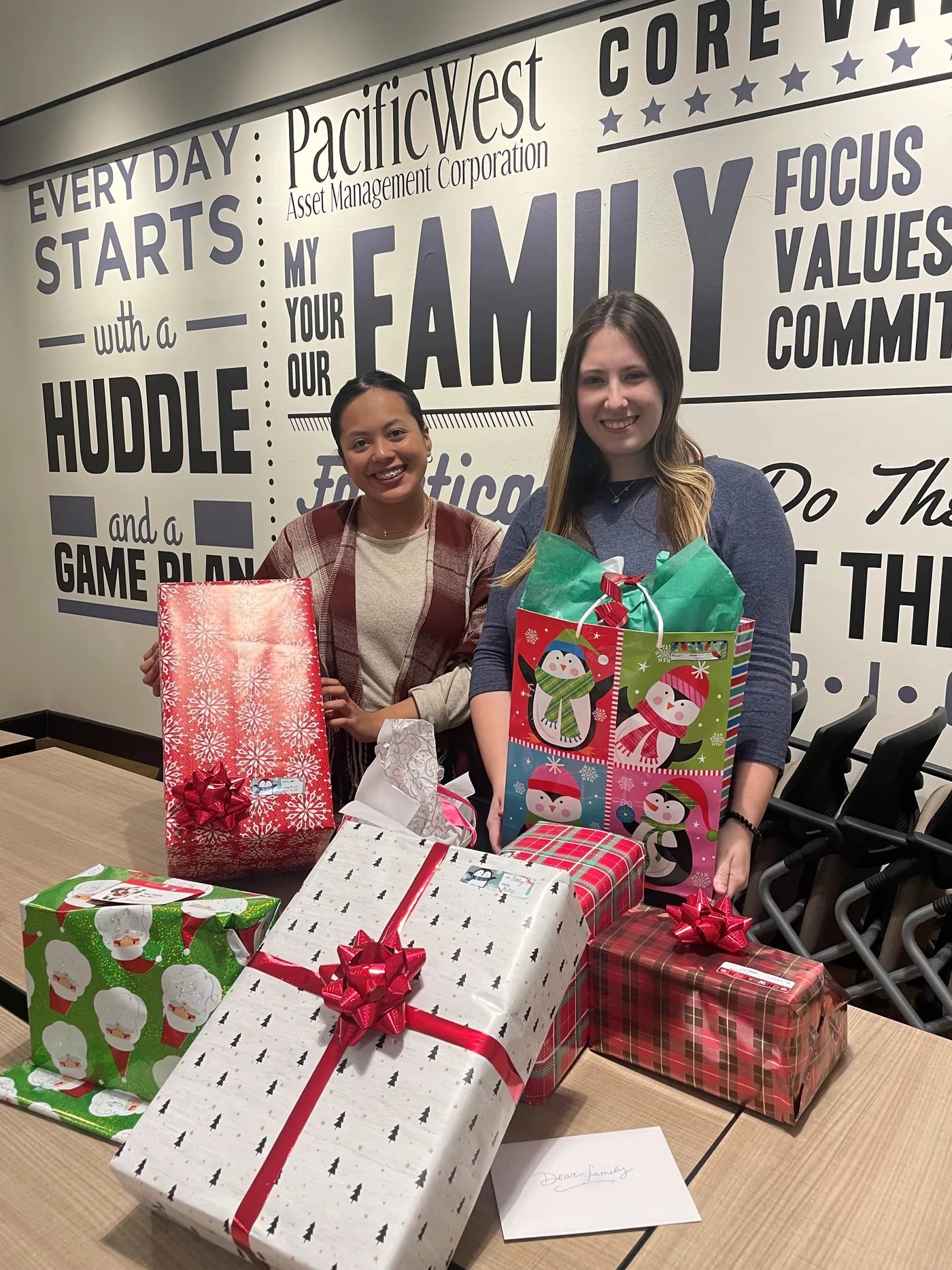 PacificWest team members with wrapped gifts during a company giving event